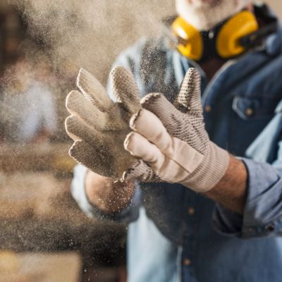 Arbeiter klopft seine Handschuhe aus